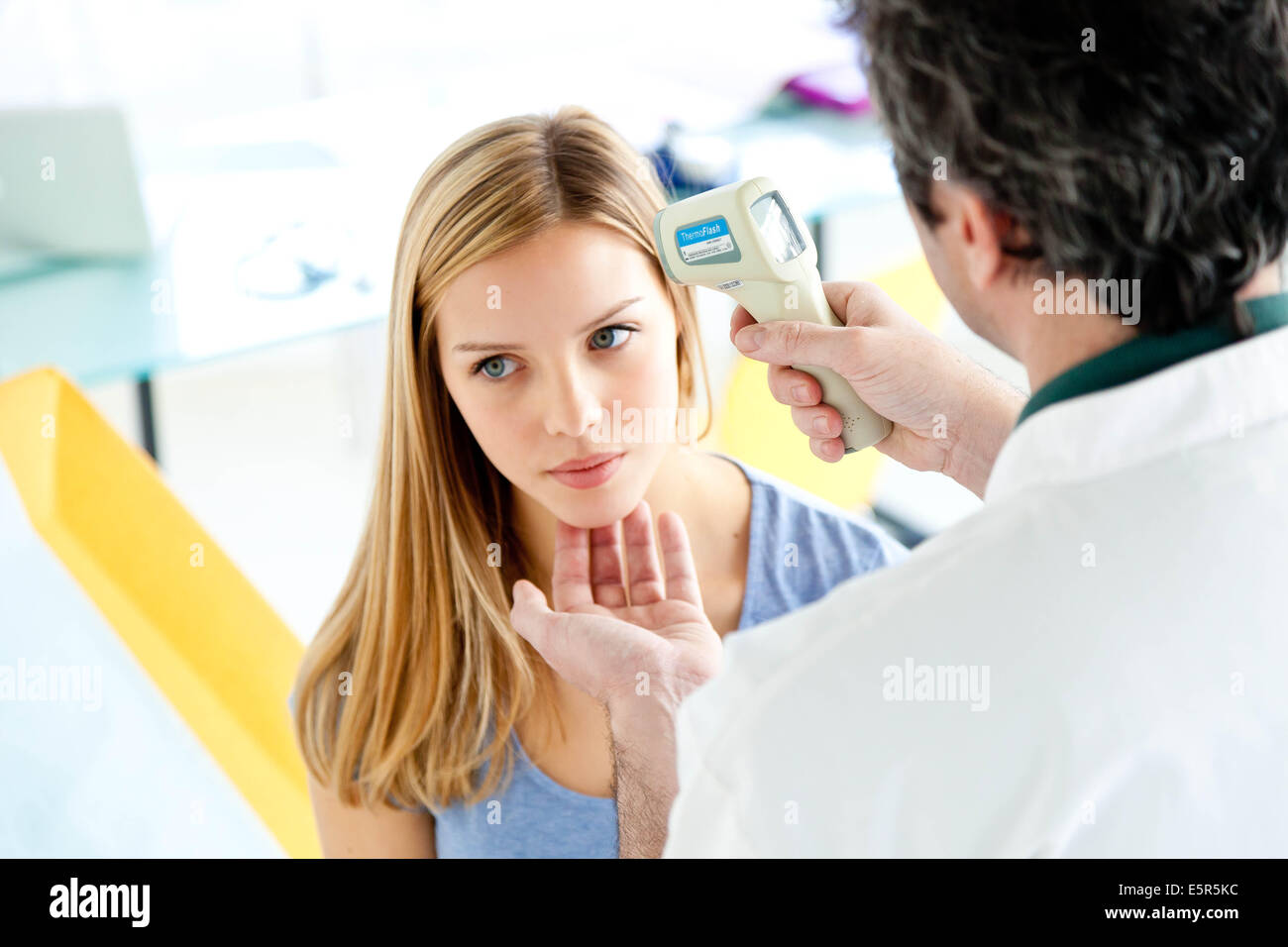 Checking the temperature of a patient with forehead thermometer Stock
