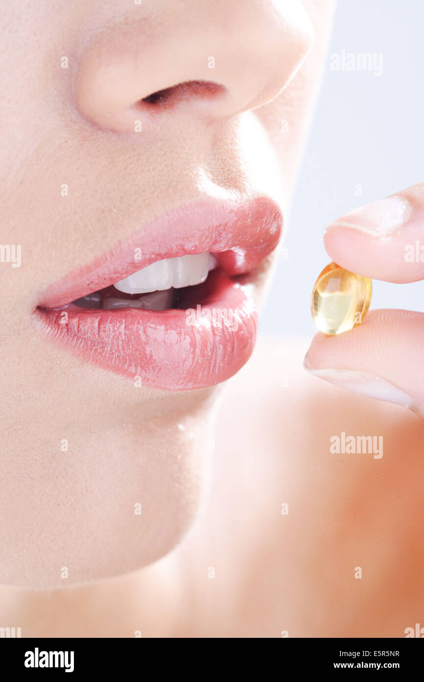 Woman taking food supplement capsules. Stock Photo