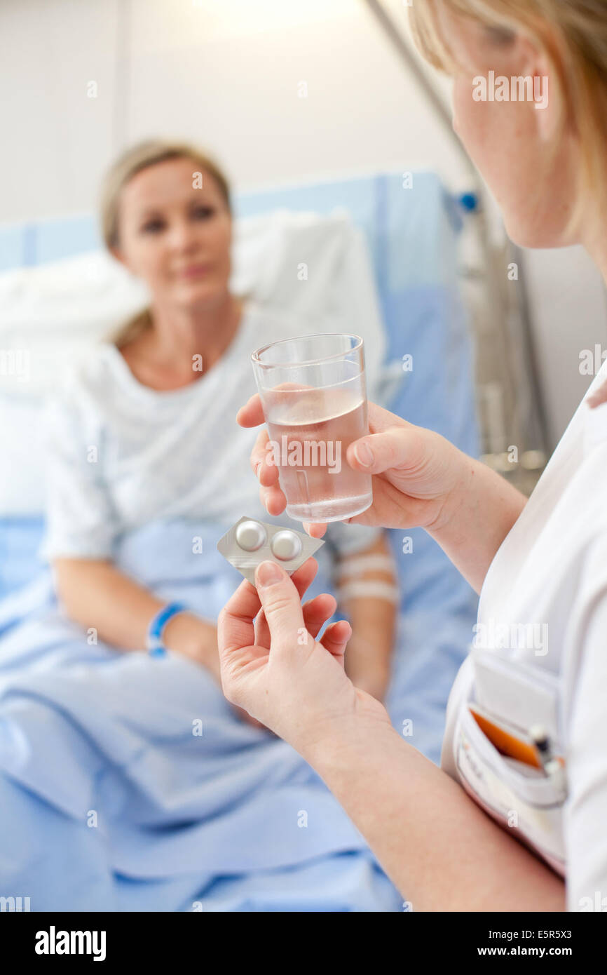 Nurse giving medication to a patient at hospital, Limoges hospital