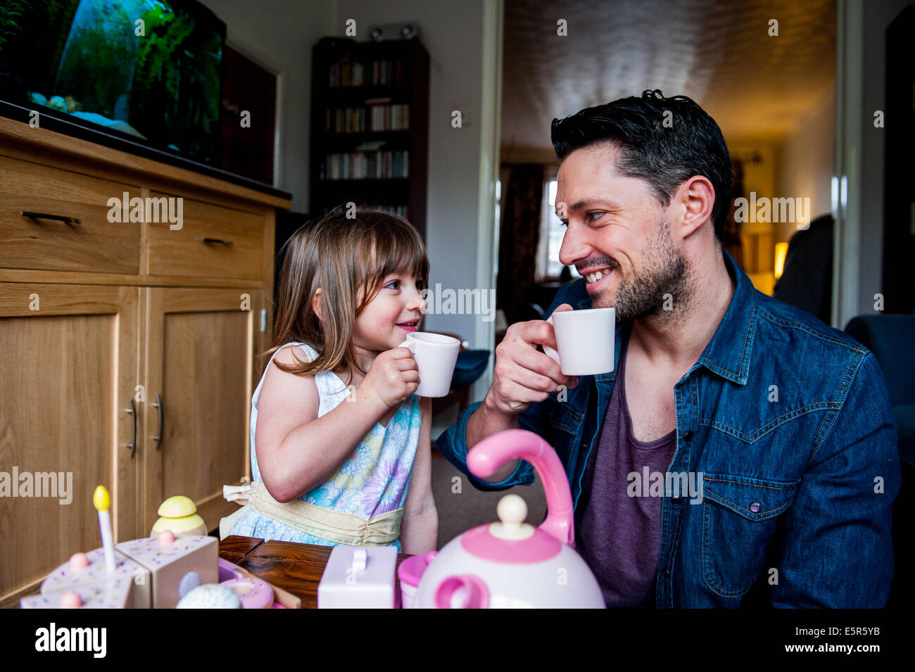 dad with his daughter and cups of tea Stock Photo