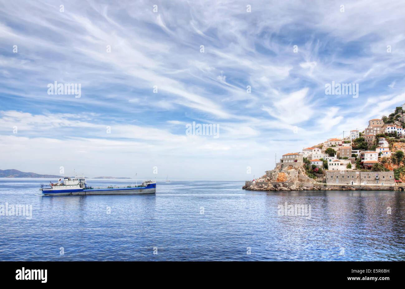 Hydra island and ship, with dramatic cloudy sky, in Greece. Stock Photo