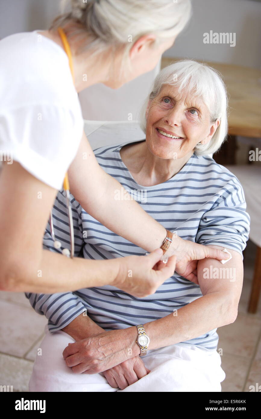 80 year old woman receiving vaccination against flu. Stock Photo