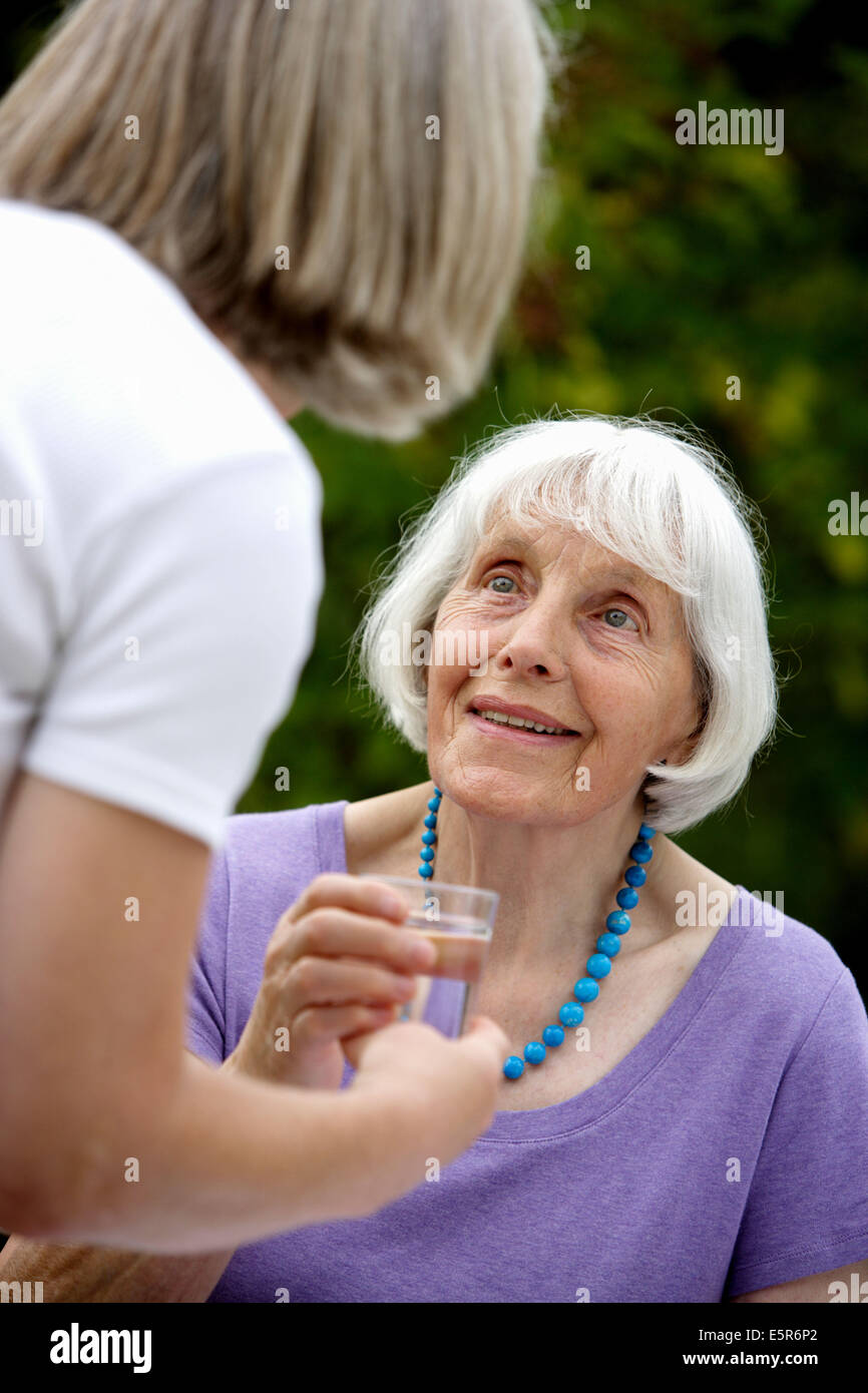 80 year old woman drinking glass of water Stock Photo Alamy