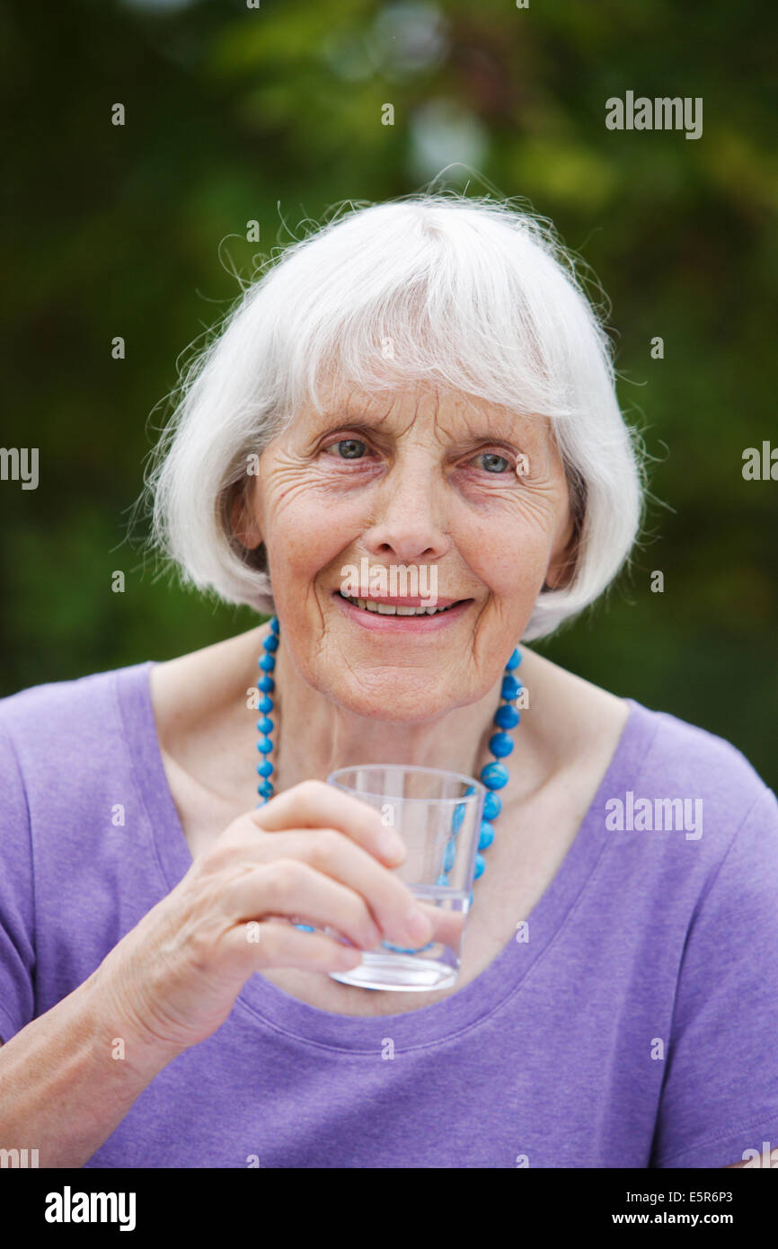 80 year old woman drinking glass of water Stock Photo Alamy
