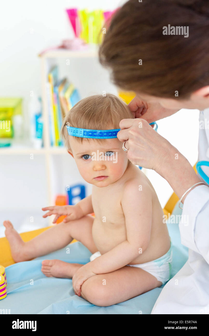 Measurement of the circumference of a 14-month-old baby's head (cranial perimeter) with a tape measure. Stock Photo