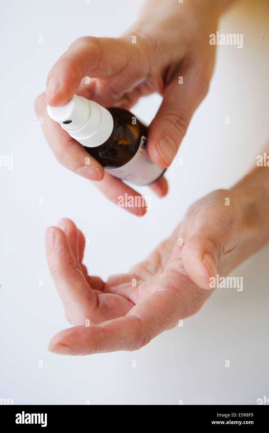 Woman using an antiseptic spray Stock Photo - Alamy