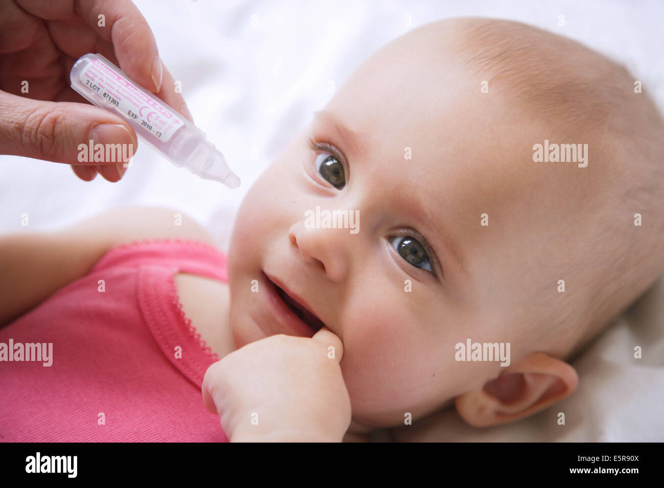 7 month old baby having his nose cleared with physiological saline