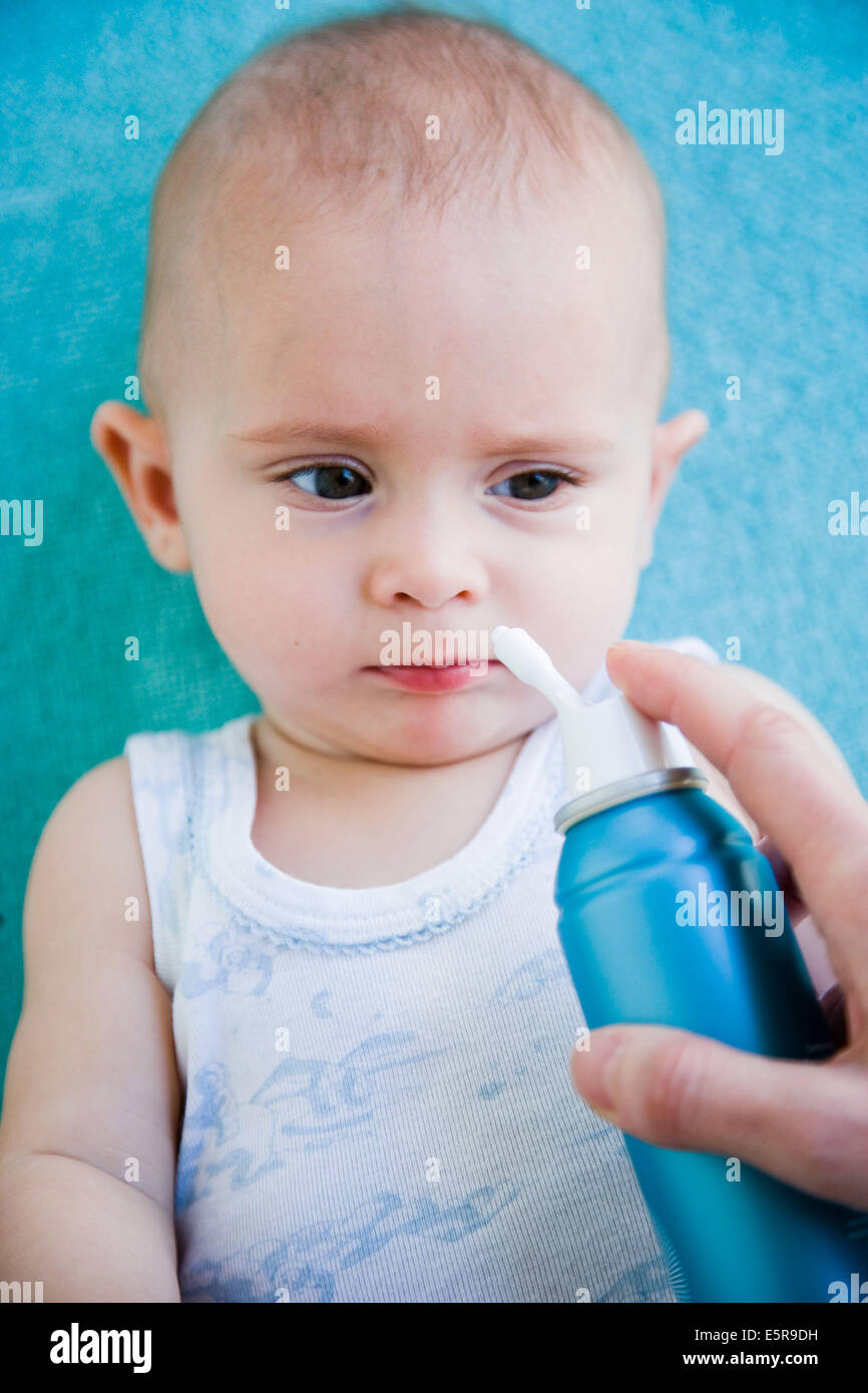 7 month old baby having his nose cleared with physiological saline