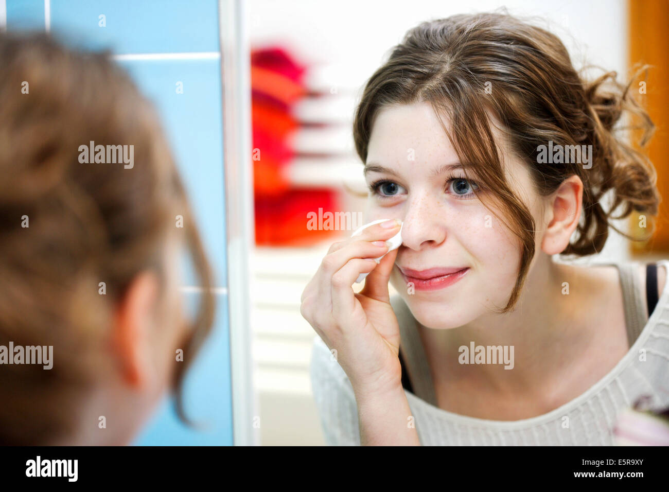 Teenage girl cleaning her face with lotion Stock Photo - Alamy