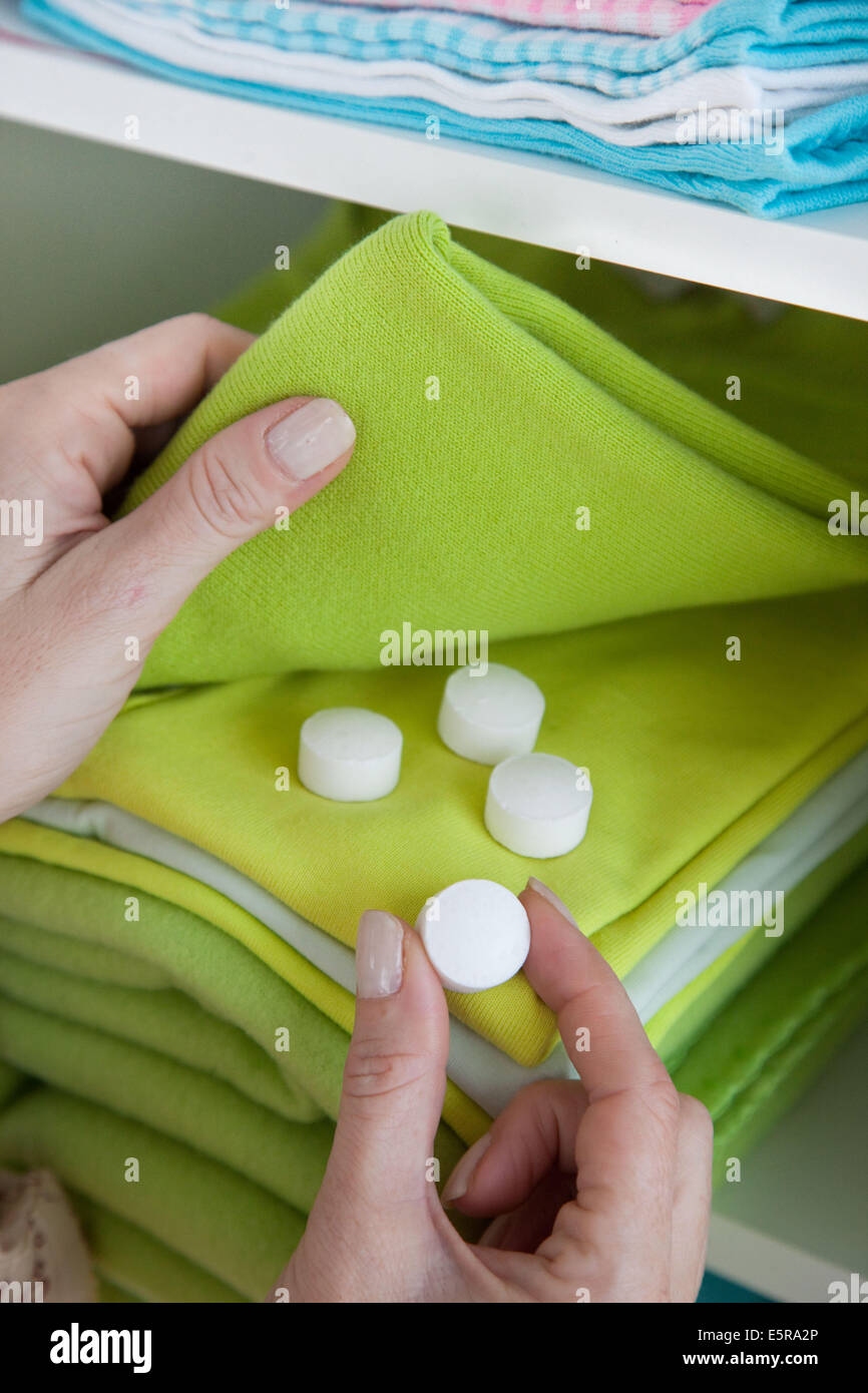 Woman placing mothballs (naphtalene) in her clothes Stock Photo