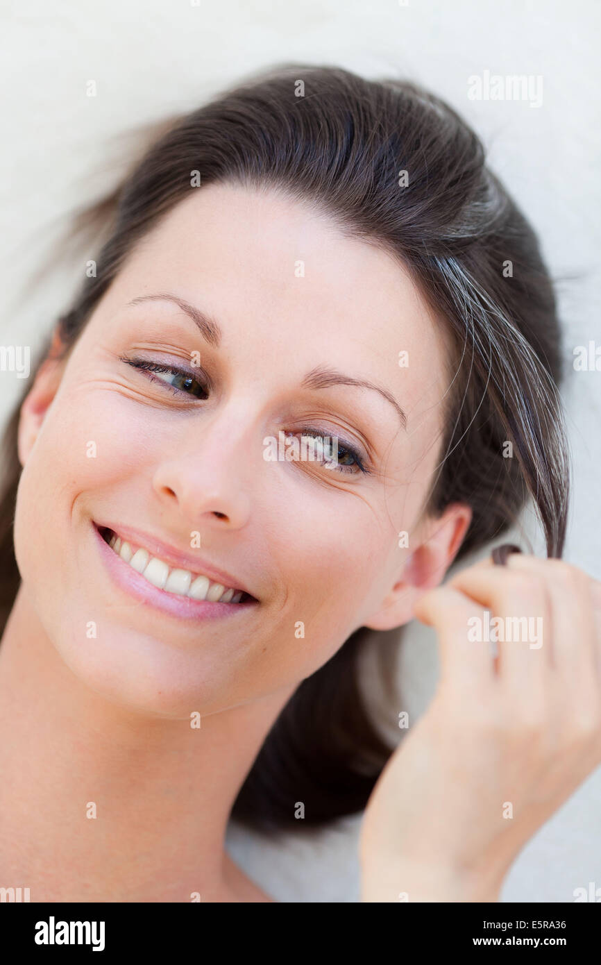 Woman looking at her white hair. Stock Photo
