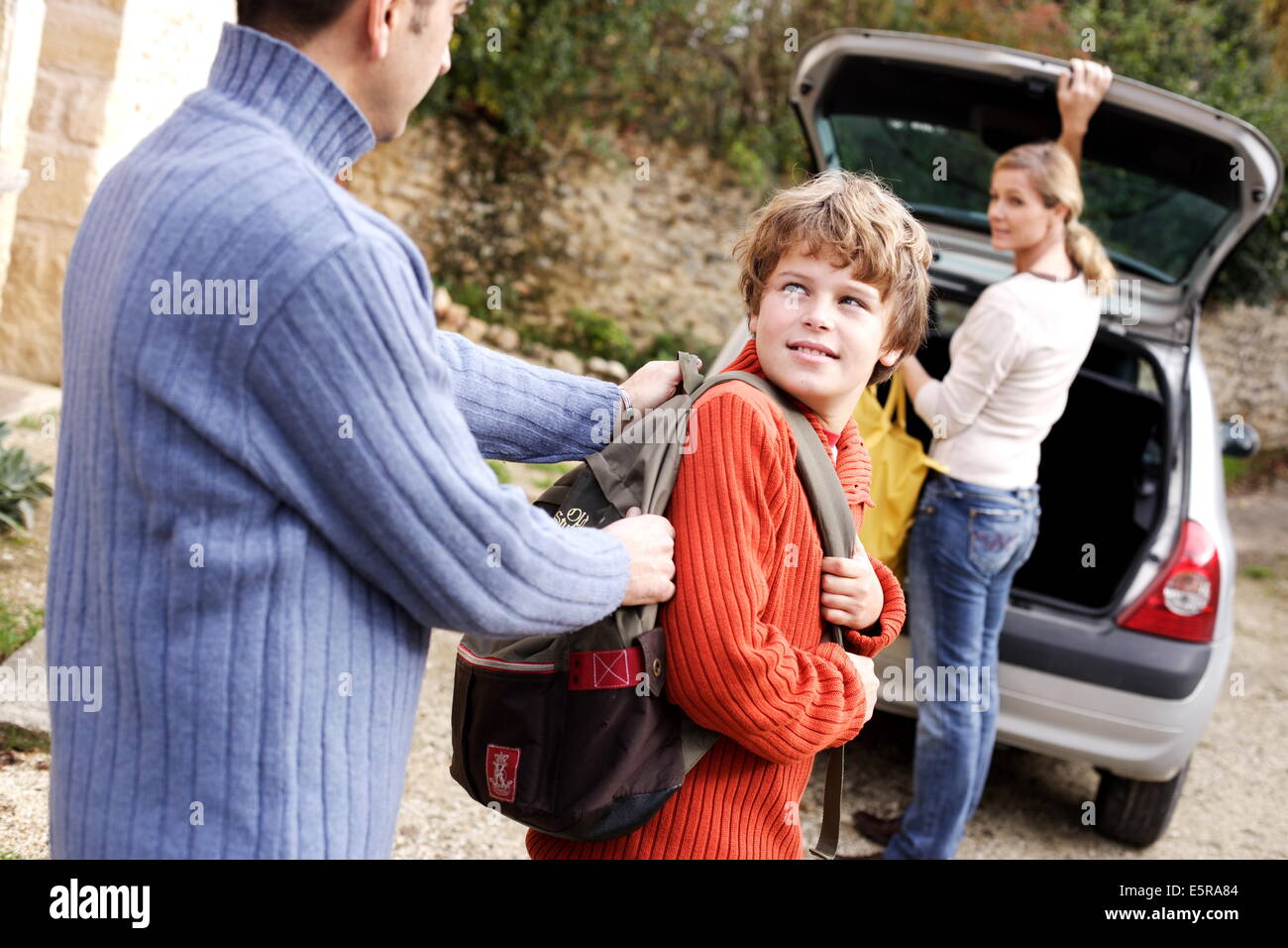 12 year old boy and parents with travel bags. Stock Photo