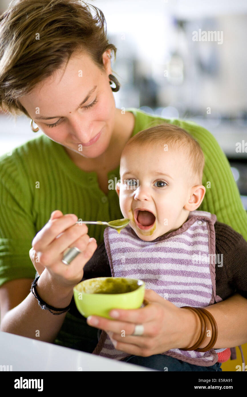 Mother spoonfeeding 12 month old baby Stock Photo Alamy