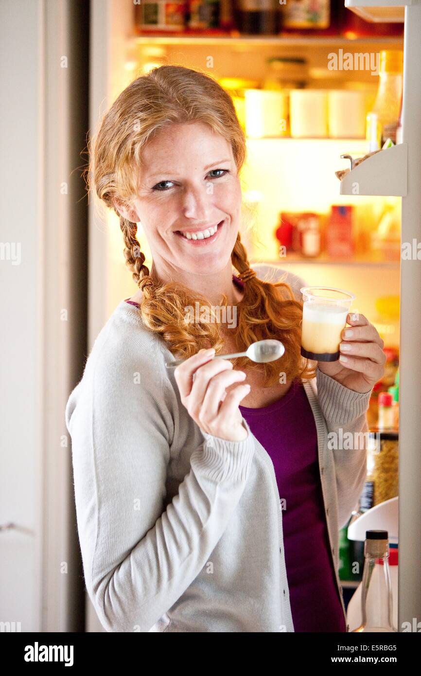 Woman eating a yogurt. Stock Photo