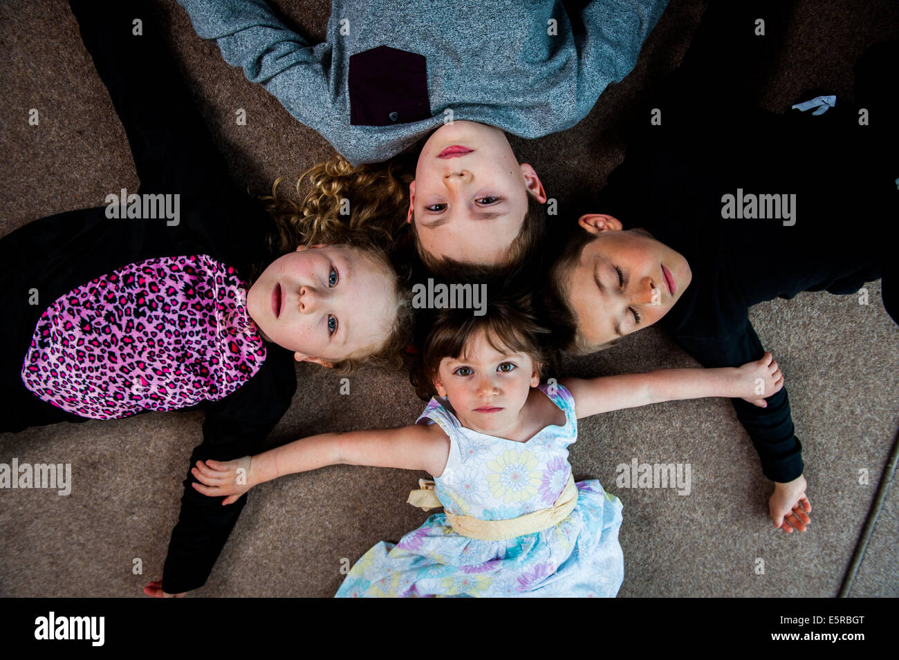 2 girls and 2 boys lying on floor shot from above Stock Photo