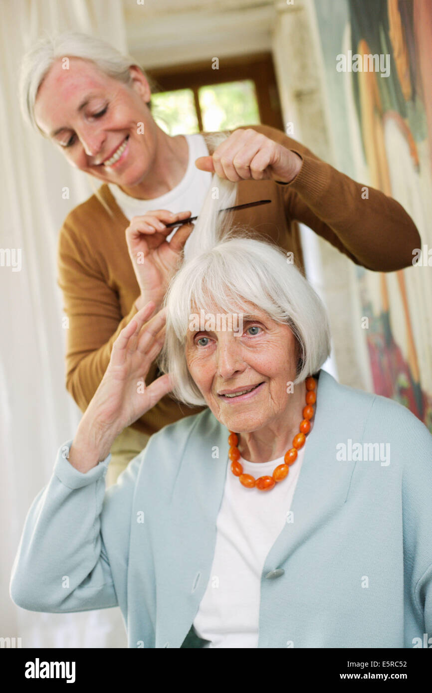 Woman brushing elderly woman's hair Stock Photo Alamy
