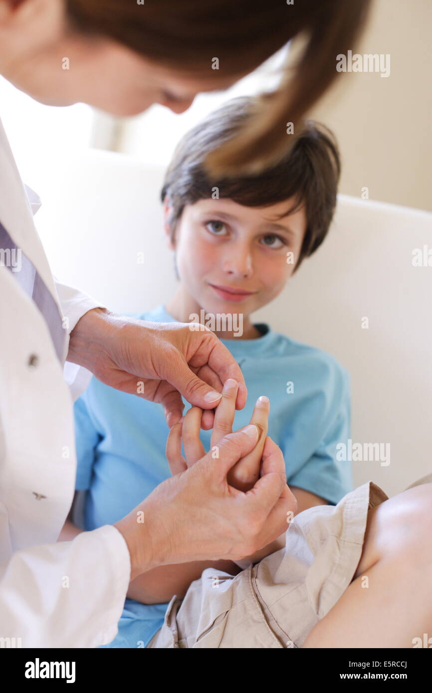 Doctor examining the hand of a 9 yearold boy Stock Photo Alamy