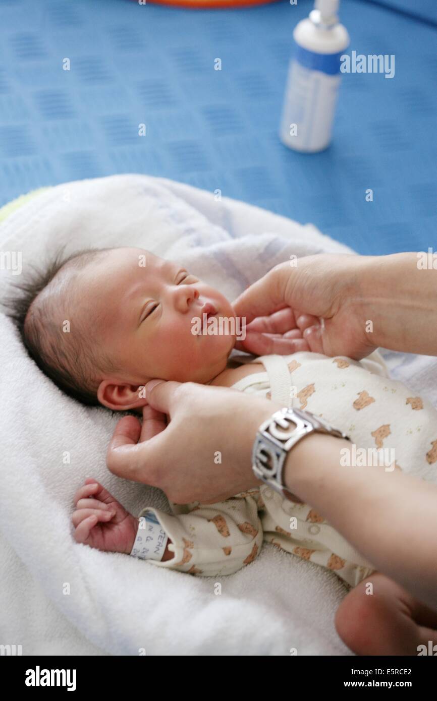Paediatric auxiliary nurse runs a to show parents how to carry