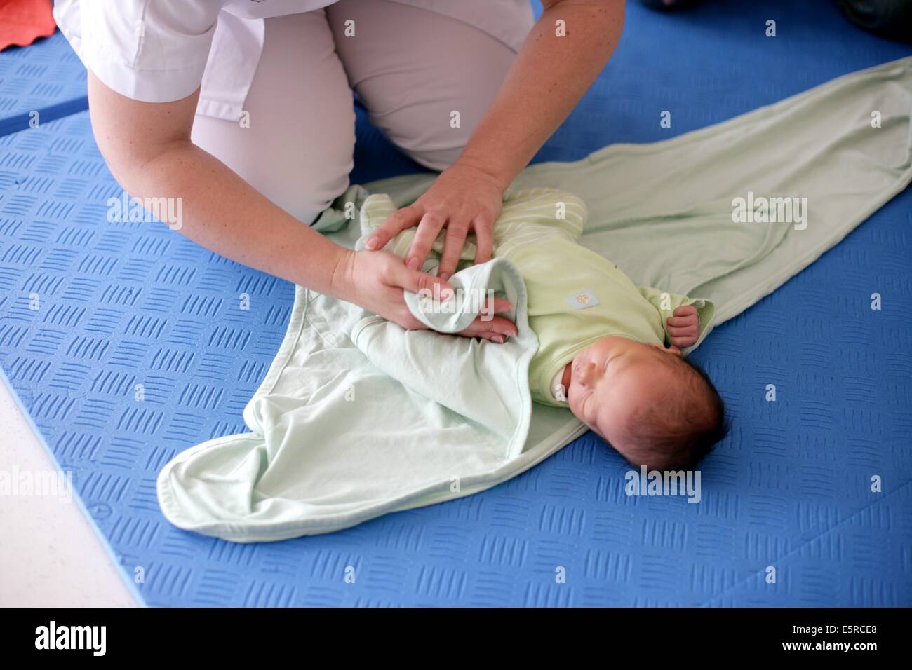 Paediatric auxiliary nurse runs a to show parents how to carry