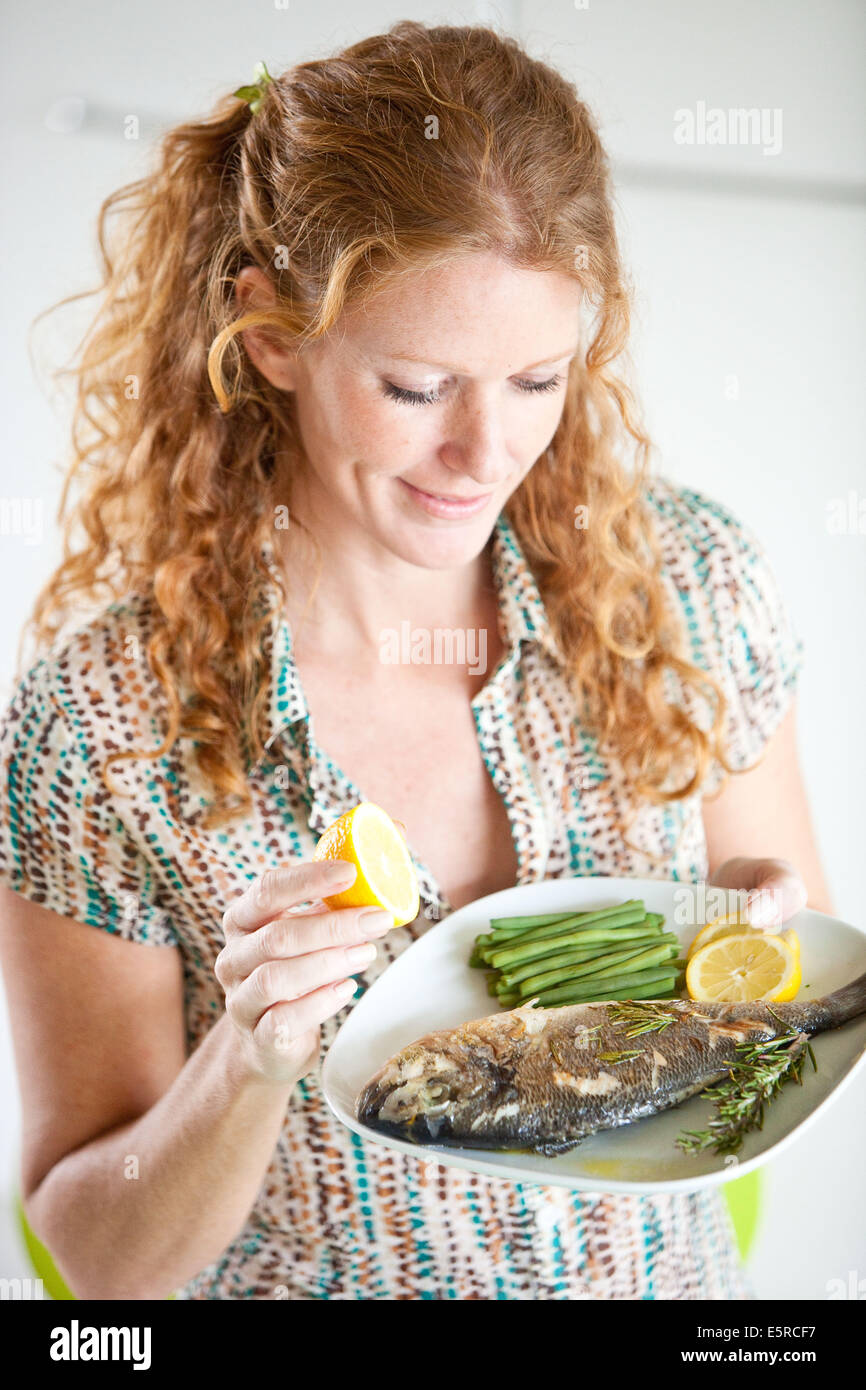 Woman eating fish and vegetables Stock Photo - Alamy