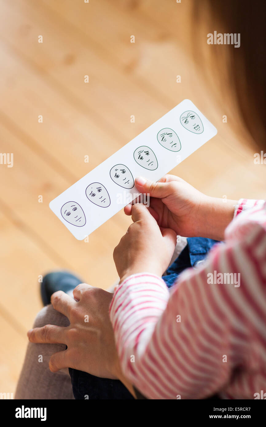 A 4 year old child explains the doctor her pain with a visual analogue pain scale. Stock Photo