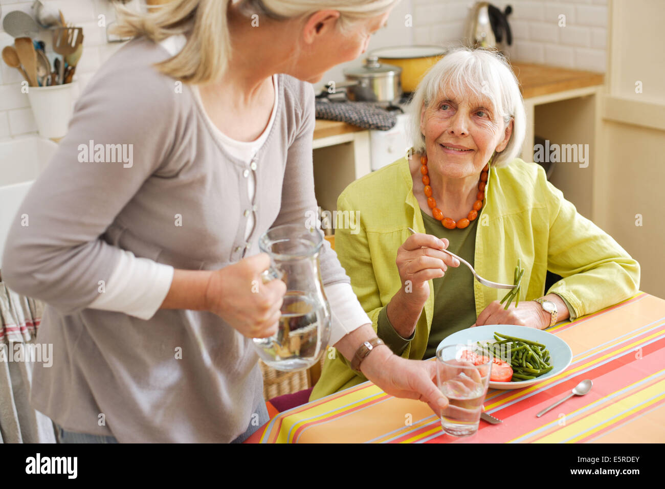 80 year old woman having lunch at home. Stock Photo