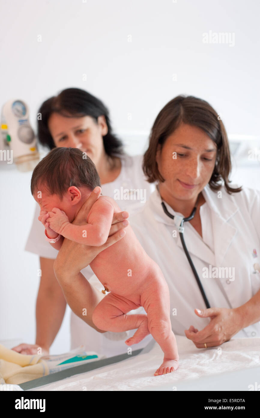 Pediatrician examining a newborn baby stepping or walking reflex