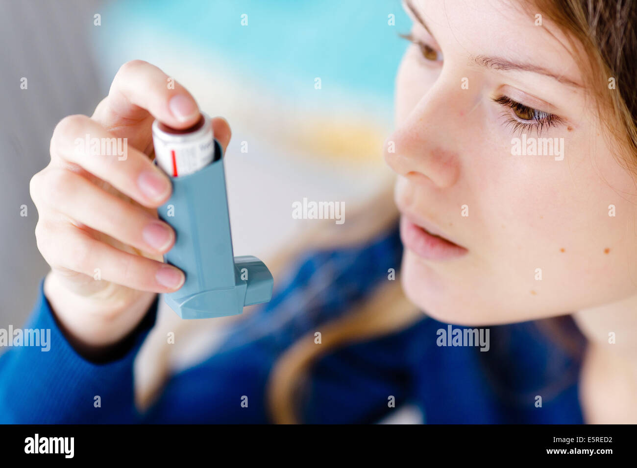 Woman using an aerosol inhaler that contains bronchodilator for the