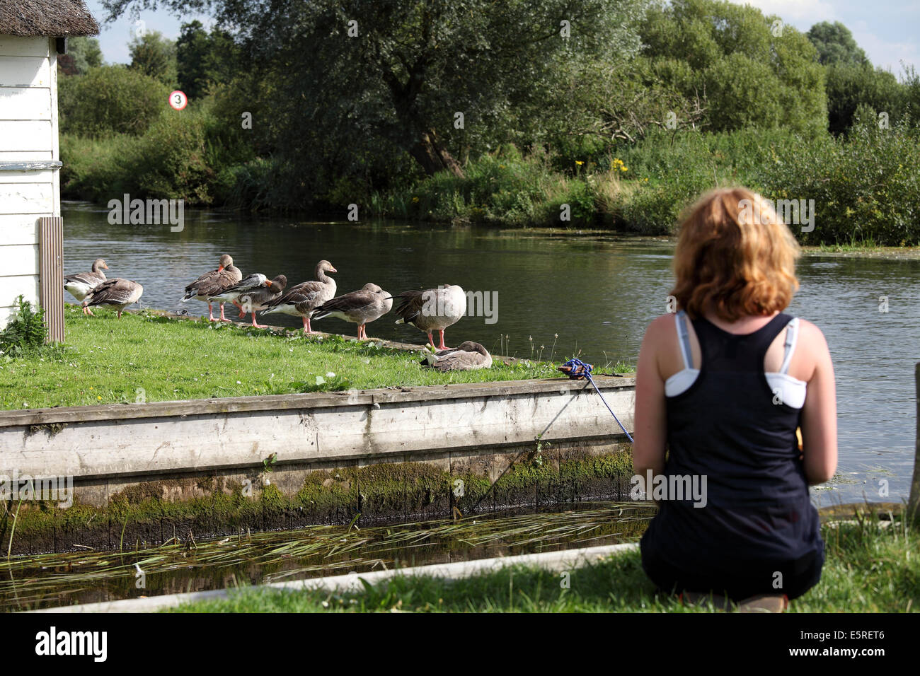Coltishall, Norfolk, UK. 4th August 2014. People were out in force today all over the Norfolk broads enjoying the summer sun. Here a woman stopped & enjoyed the scenery of Coltishall.. Credit:  Paul Lilley/Digitalshot/Alamy Live News Stock Photo