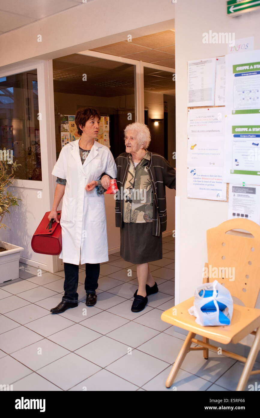 Liberal nurse in rural environment during home visit in foster home for elderly person Stock