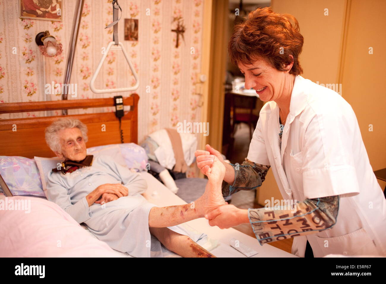 Liberal nurse in rural environment giving an elderly person a massage to  prevent eschars Stock Photo - Alamy