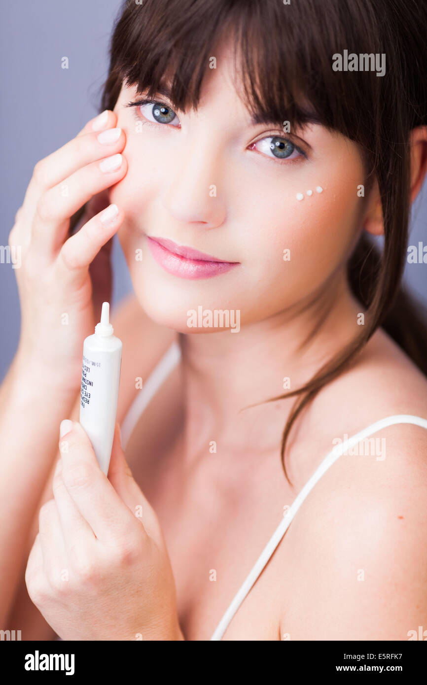 Woman applying anti-wrinkle cream around the eyes. Stock Photo