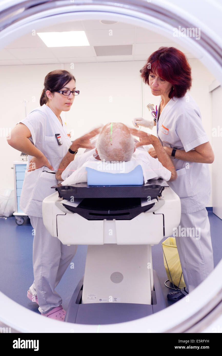Elderly male patient talking to radiotherapy radiographers during