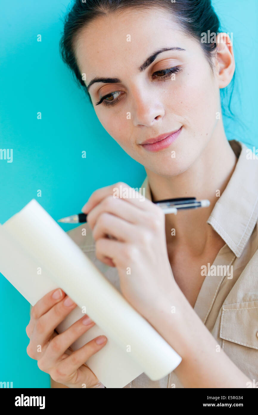 Woman writing in her diary. Stock Photo
