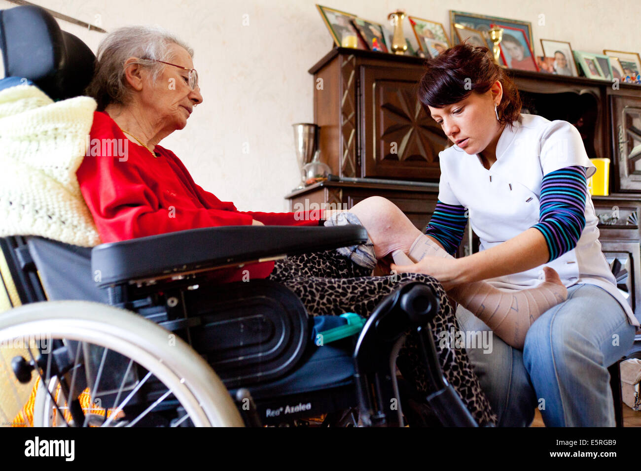 Physiotherapy session at the home of an elderly woman with a disability. Stock Photo