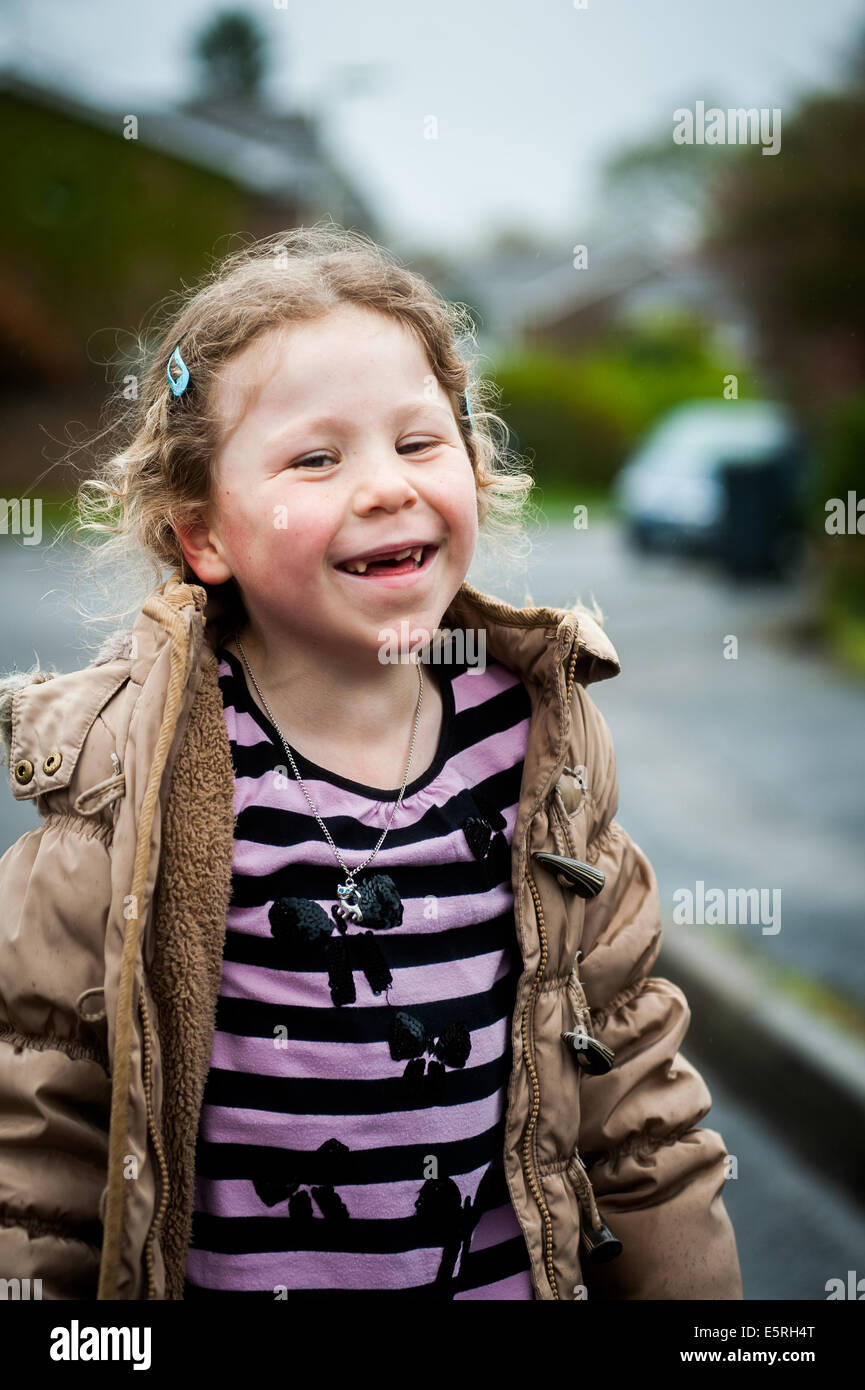 girl of 6 7 8 9 laughing in street Stock Photo