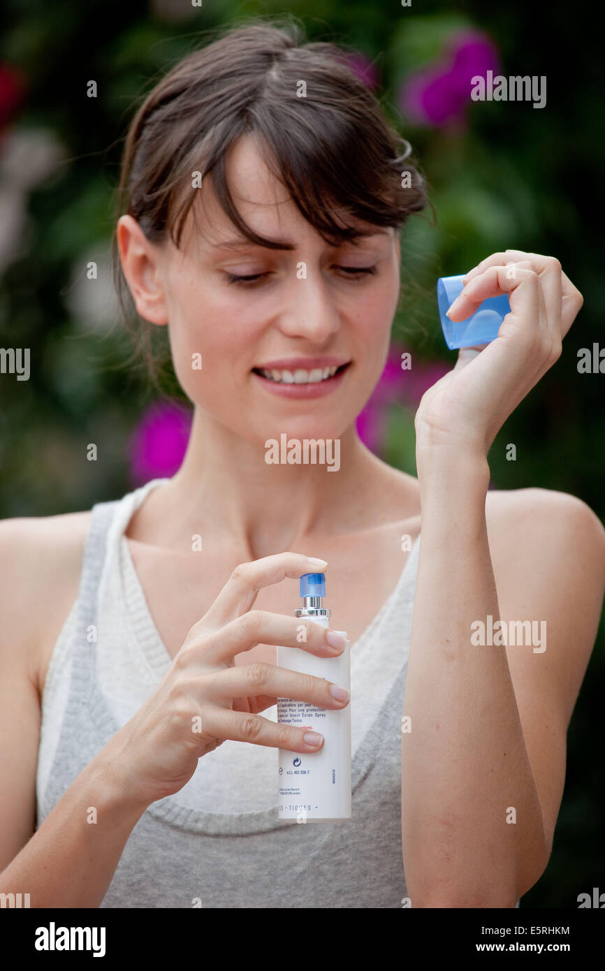 Woman applying spray against insect bites and itching. Stock Photo
