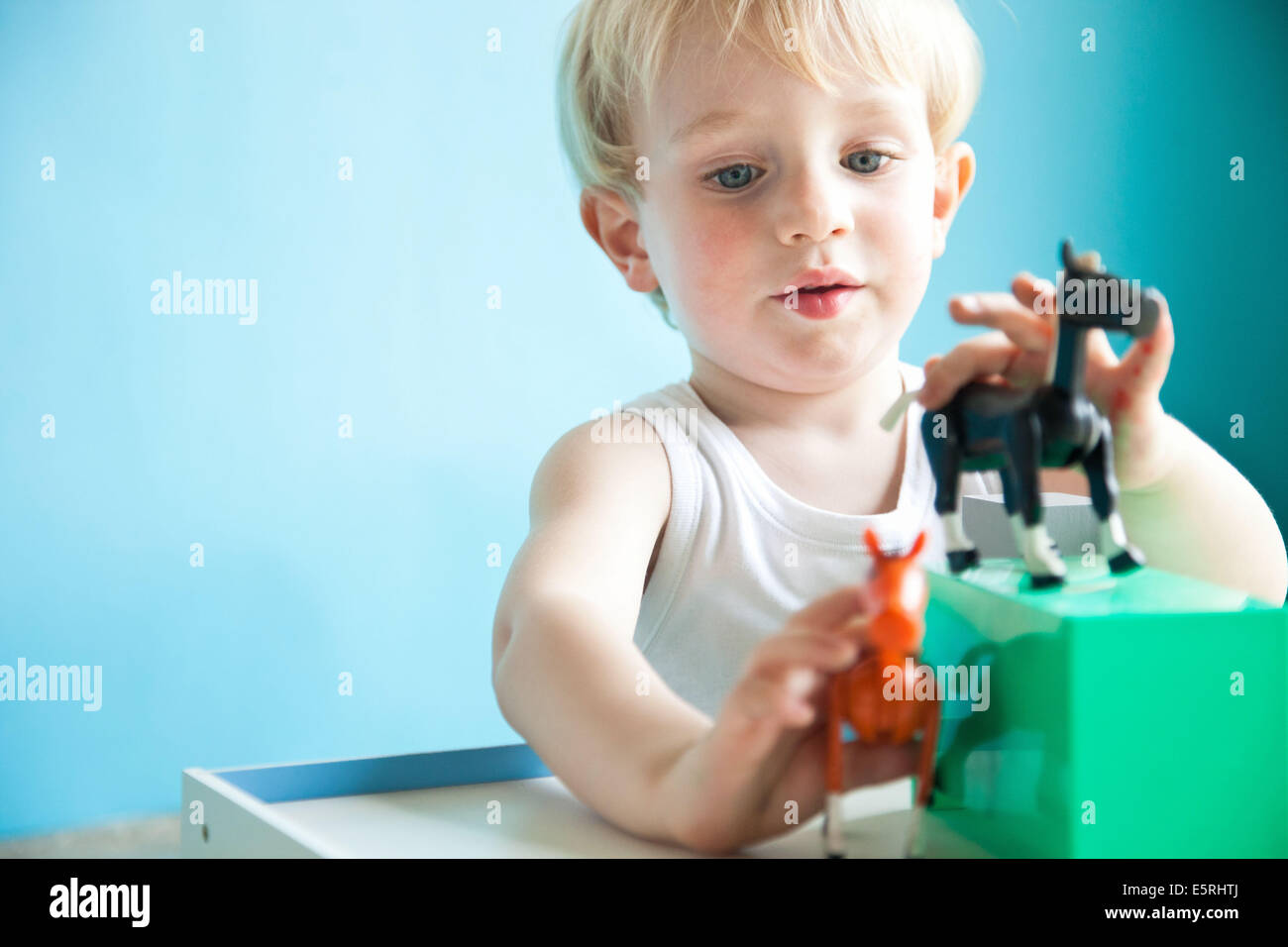 3yearold boy playing with figurines Stock Photo Alamy