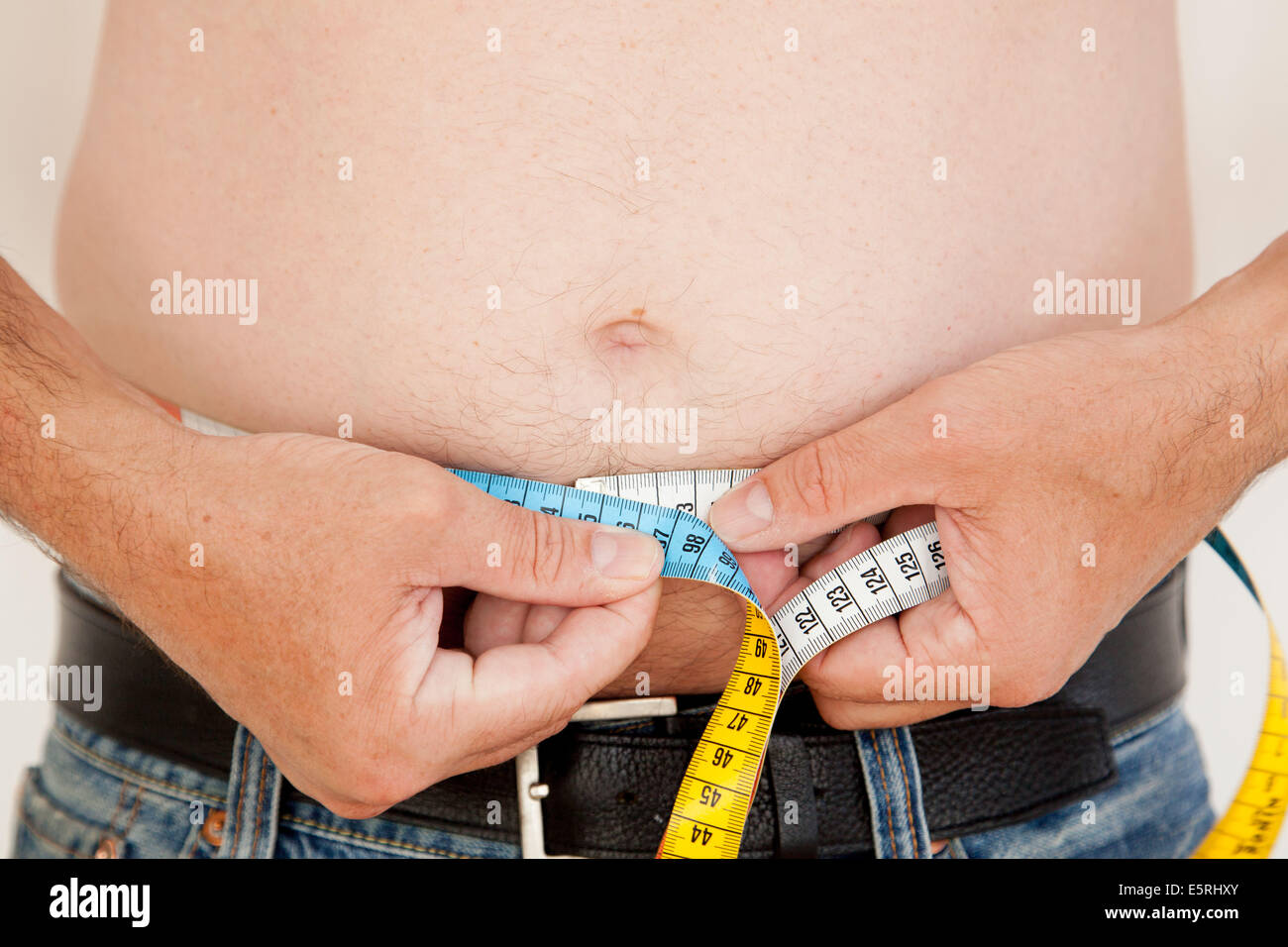 Man measuring his waist with a tape measure 2246454 Stock Photo at Vecteezy