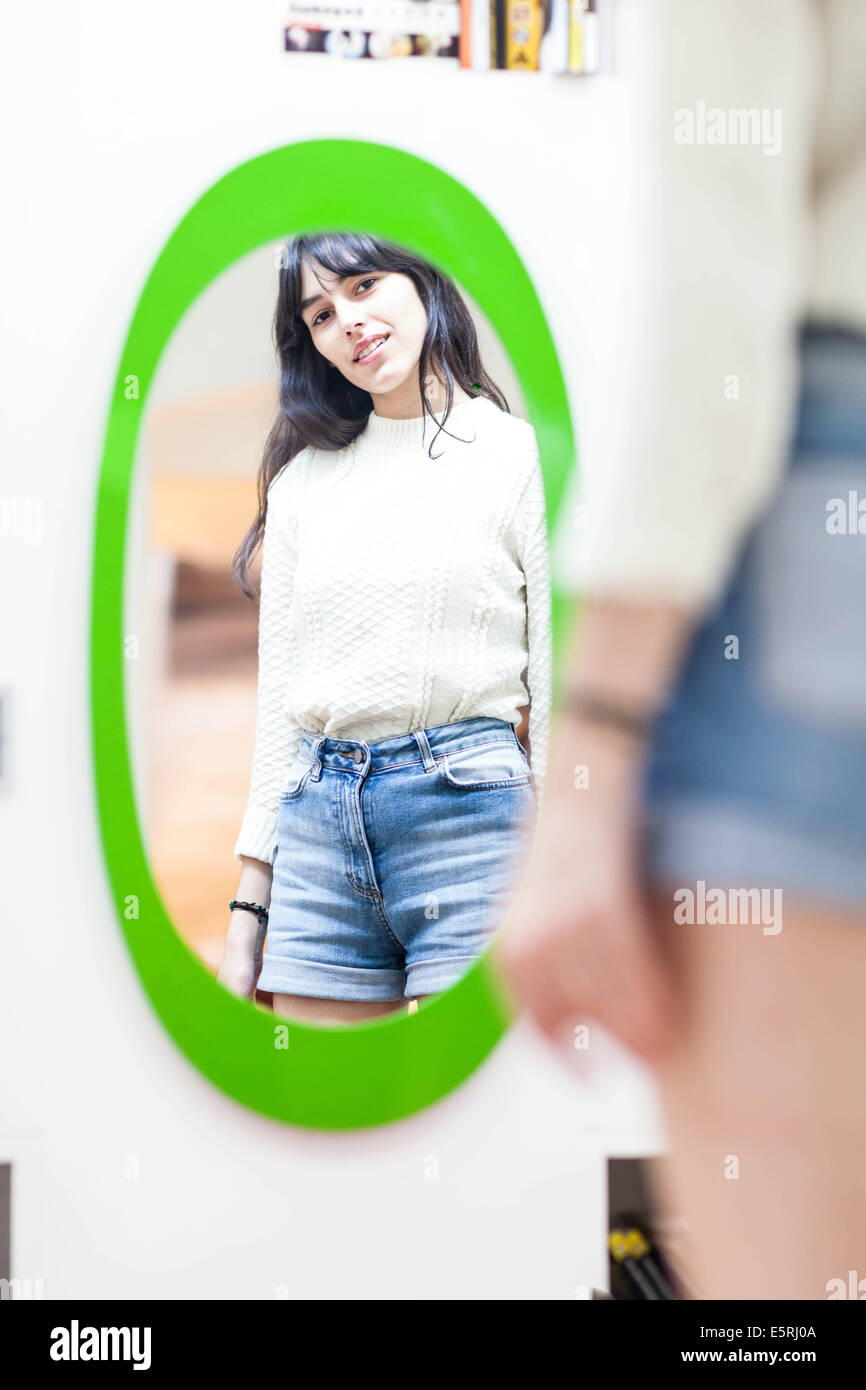 Young woman watching her in mirror. Stock Photo