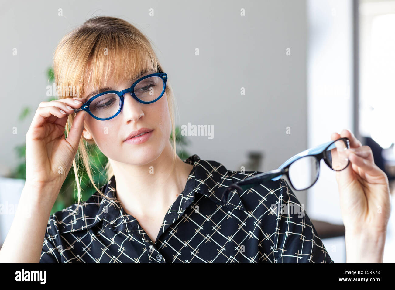 Woman trying different frames for prescription glasses at the optician