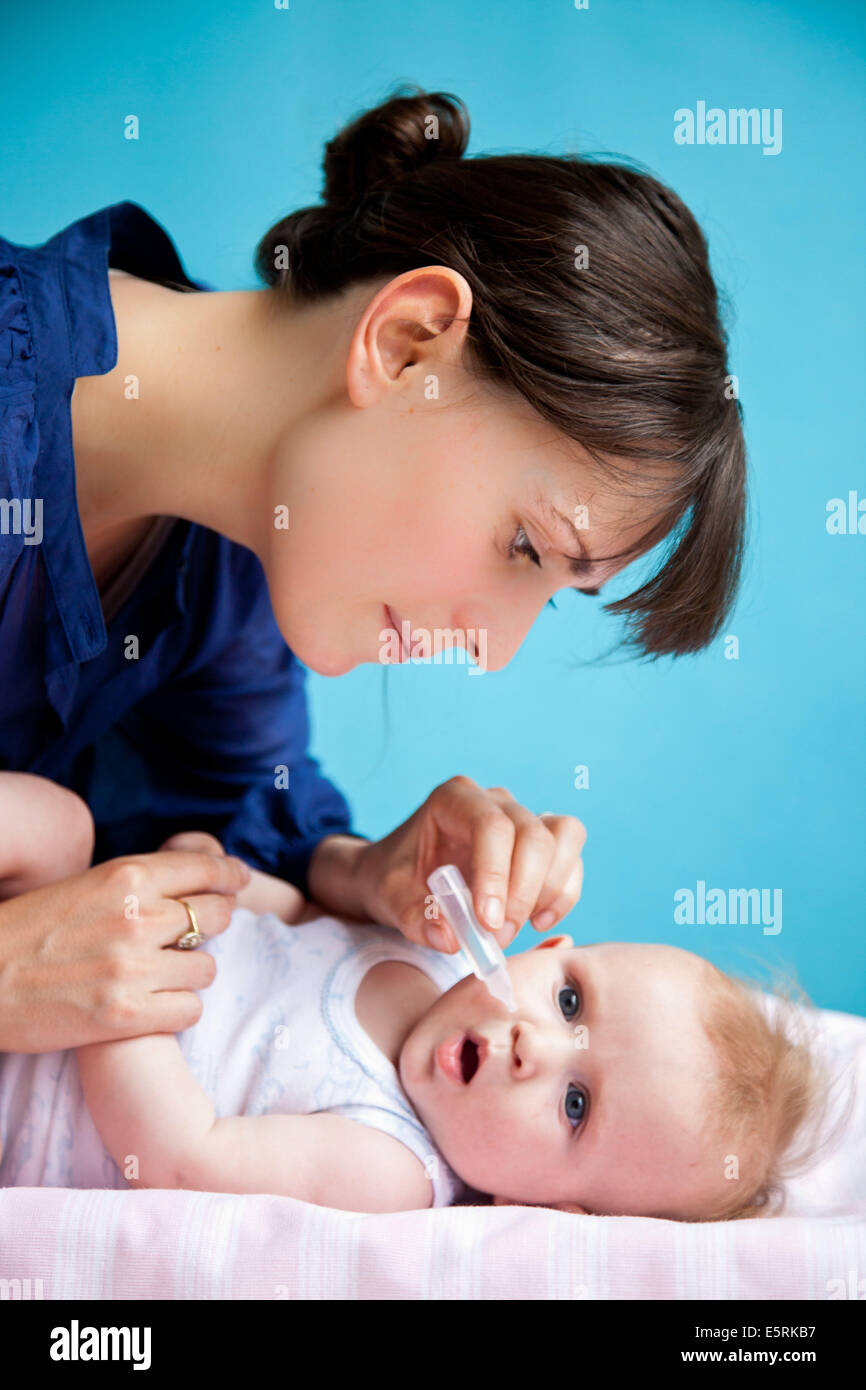 5 month old baby having nose cleared with physiological saline solution