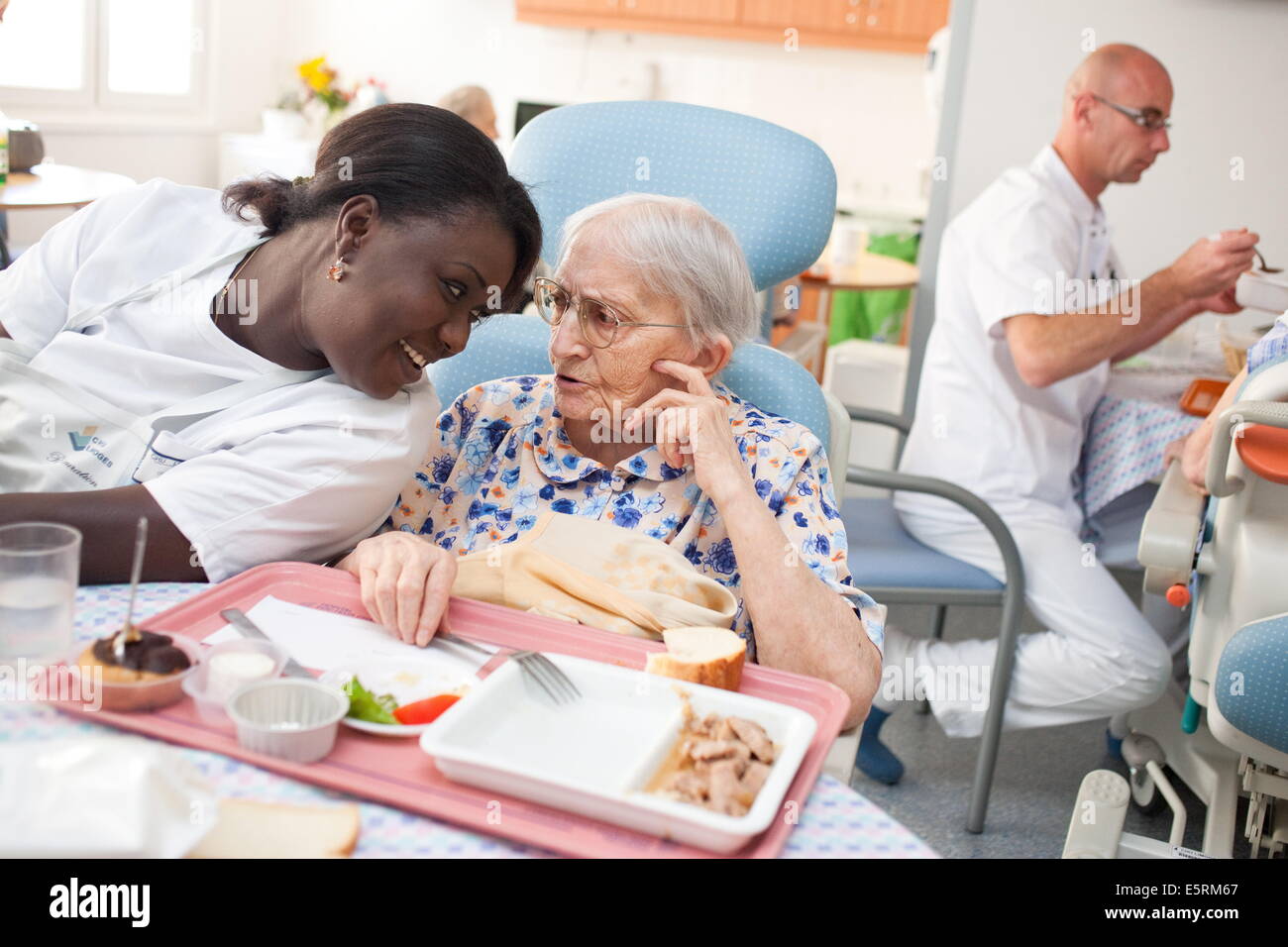 Auxiliary nurse helping an elderly person to take meal; Residential home for dependent elderly person, Limoges, France. Stock Photo