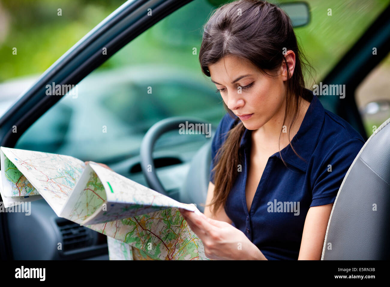 Woman driver reading a road map. Stock Photo