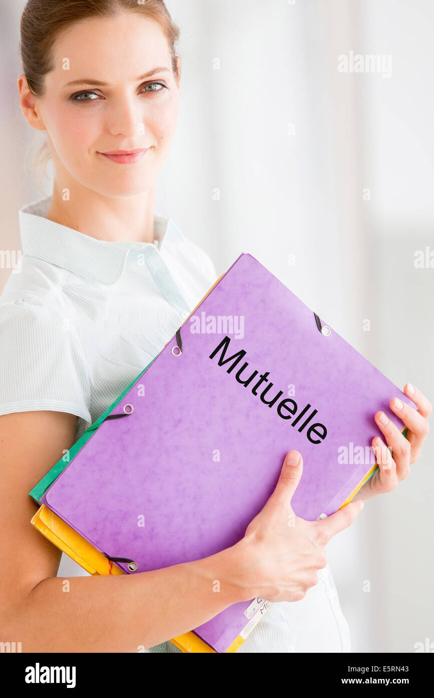 Woman holding complementary health insurance company folder. Stock Photo