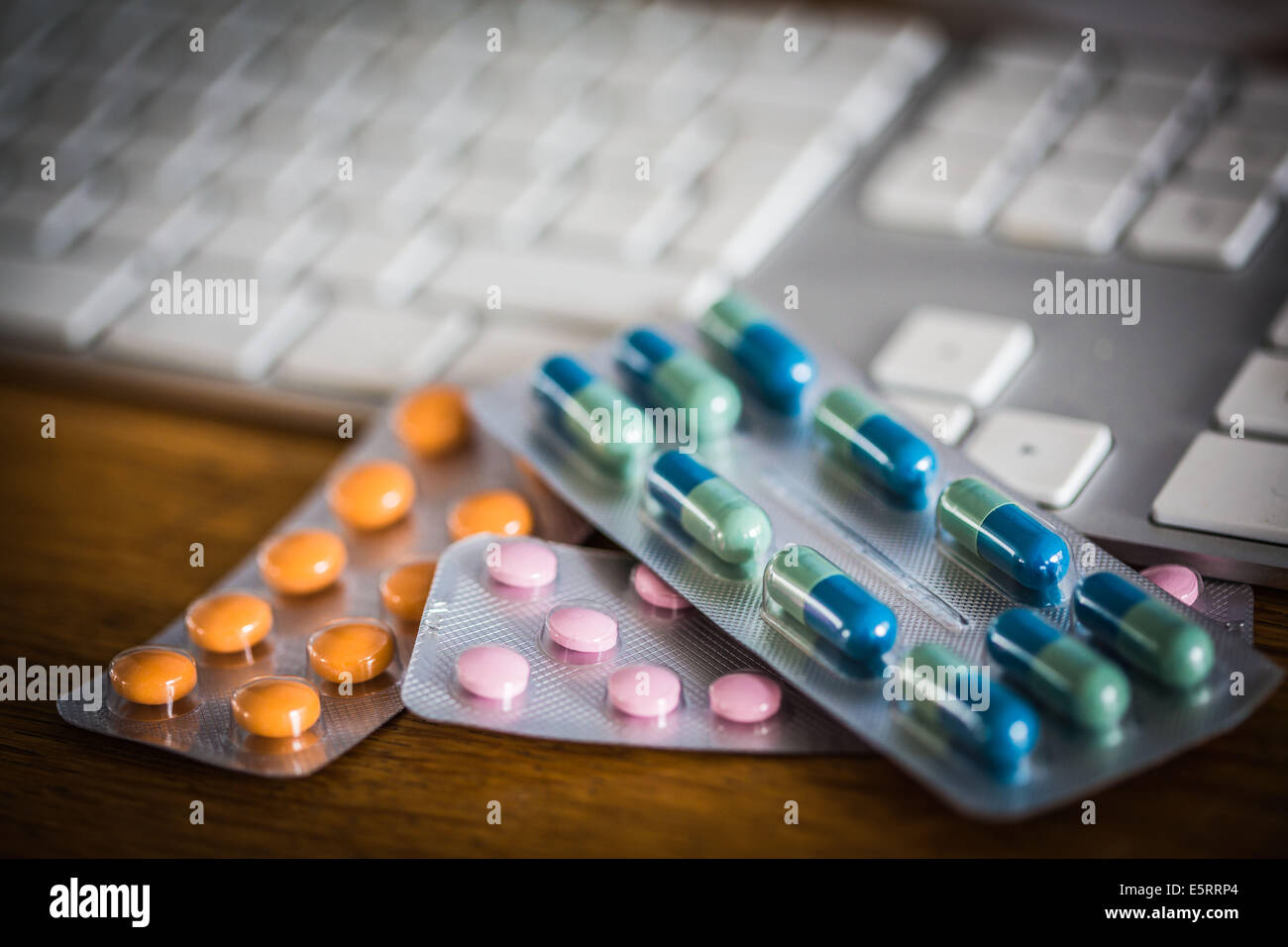 Drugs on a computer keyboard to illustrate buying medicines online. Stock Photo