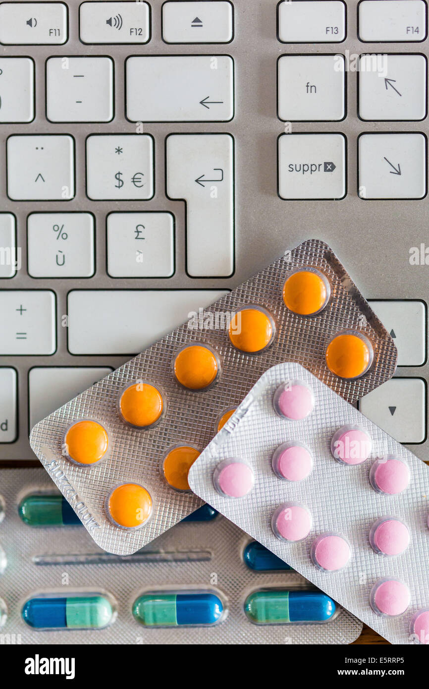 Drugs on a computer keyboard to illustrate buying medicines online. Stock Photo