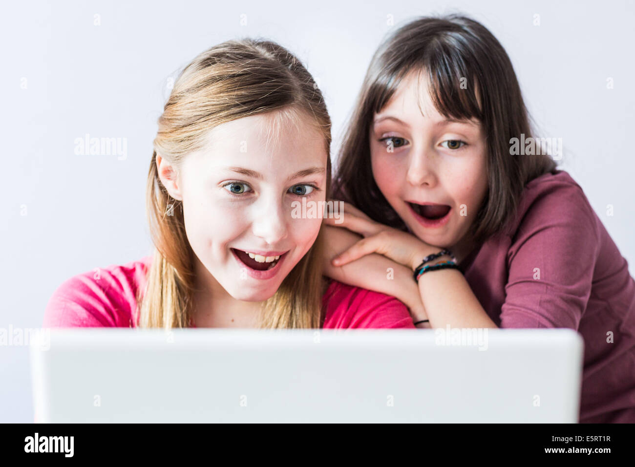 Sisters using laptop computer Stock Photo - Alamy