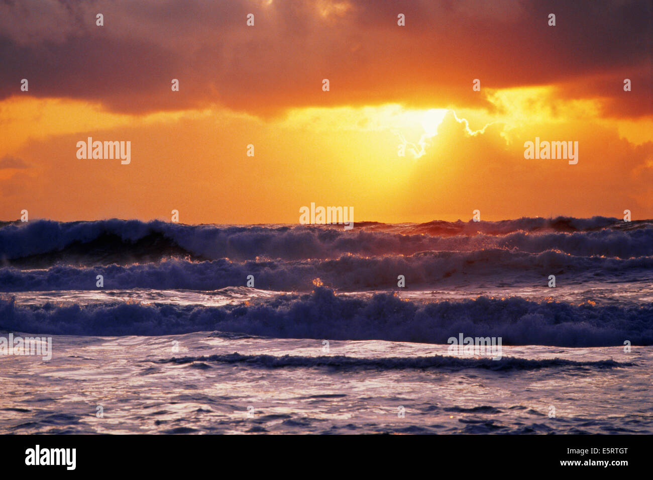 Waves breaking on shore at sunset off the California coast Stock Photo