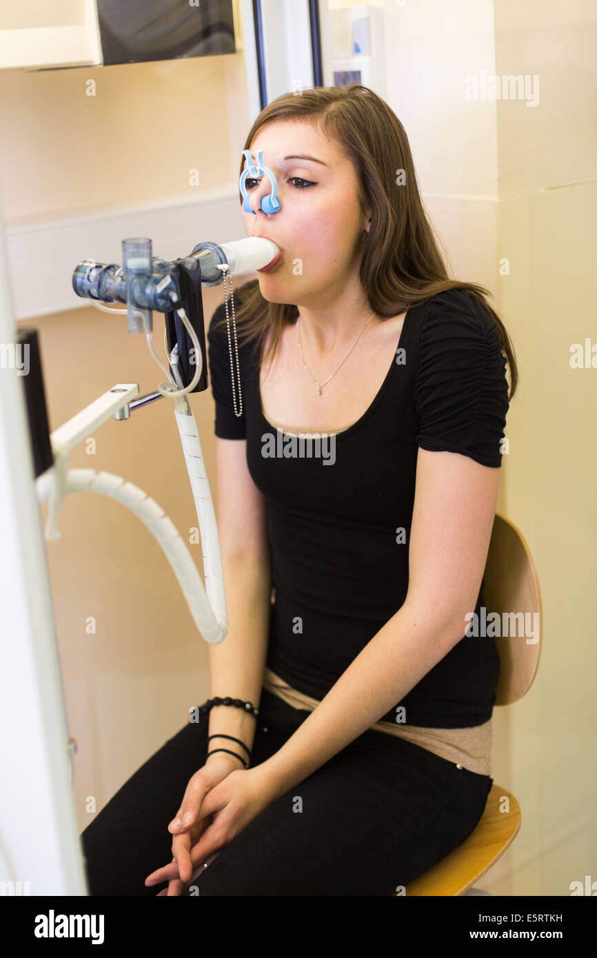 Annual Review of a 22 year old girl suffering from mucoviscidosis breathing into a spirometer. Limoges hospital, France. Stock Photo
